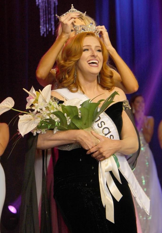 Model in a black dress with flowers and a crown